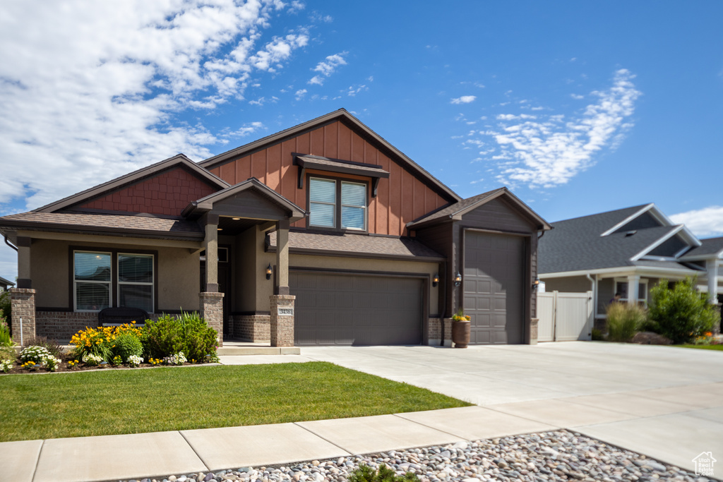 Craftsman-style house with driveway, board and batten siding, a garage, stucco siding, and a shingled roof