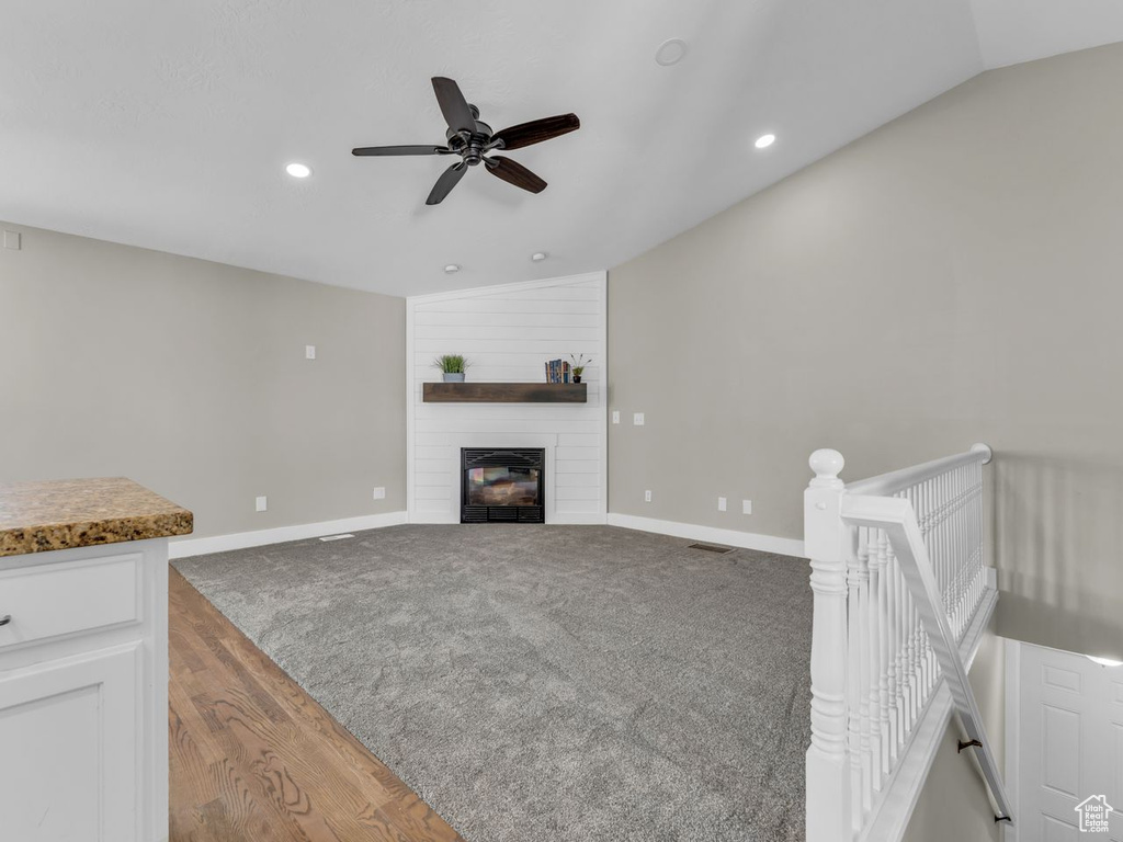Unfurnished living room with a fireplace, baseboards, ceiling fan, vaulted ceiling, and recessed lighting