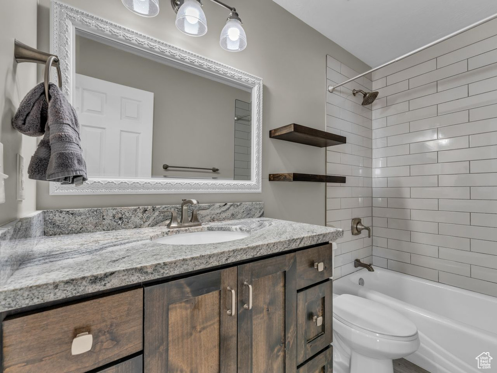 Bathroom featuring toilet, vanity, and shower / washtub combination