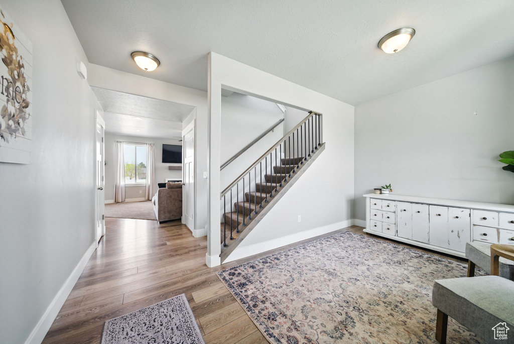 Foyer featuring baseboards, light wood-style flooring, and stairway