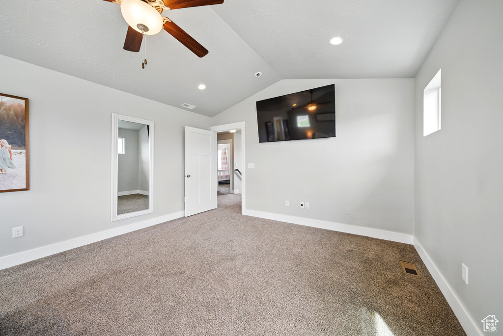 Carpeted spare room with a ceiling fan, lofted ceiling, baseboards, and recessed lighting