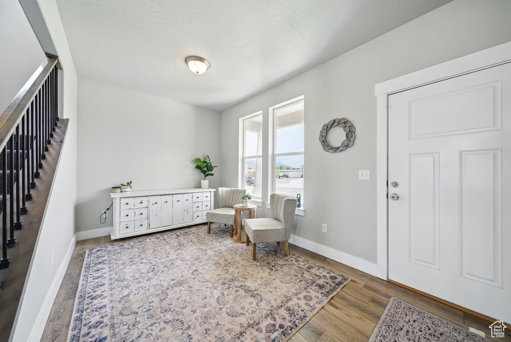 Sitting room with wood finished floors, baseboards, and a textured ceiling