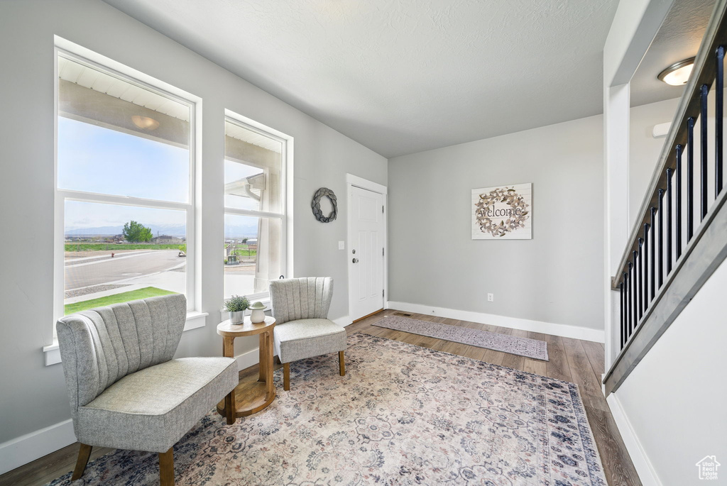 Living area with wood finished floors, baseboards, and stairway