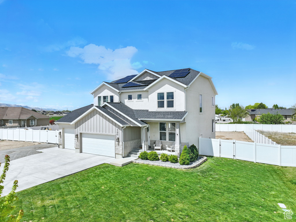 Traditional home with solar panels, a gate, a porch, board and batten siding, and a shingled roof
