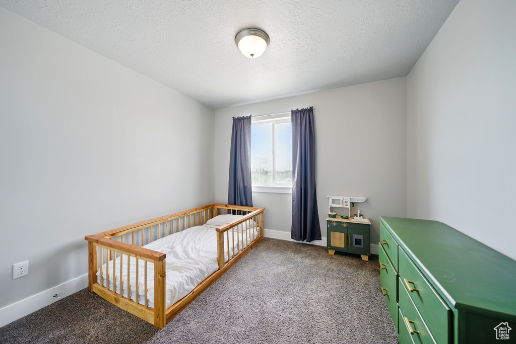 Bedroom with carpet flooring, baseboards, and a nursery area