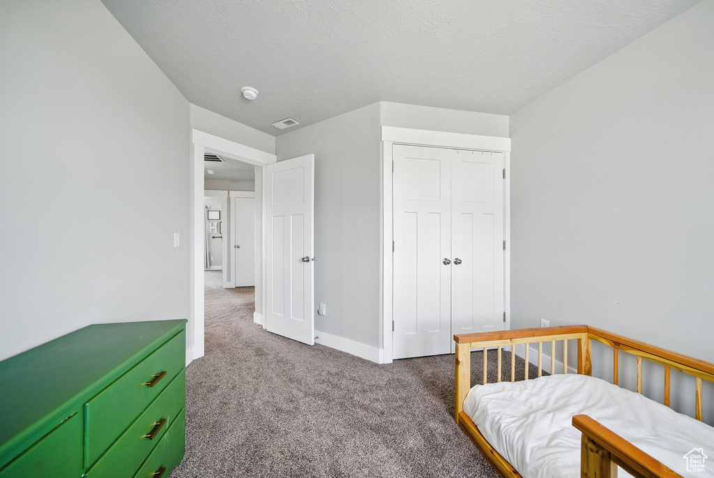 Bedroom featuring carpet flooring, baseboards, and a closet