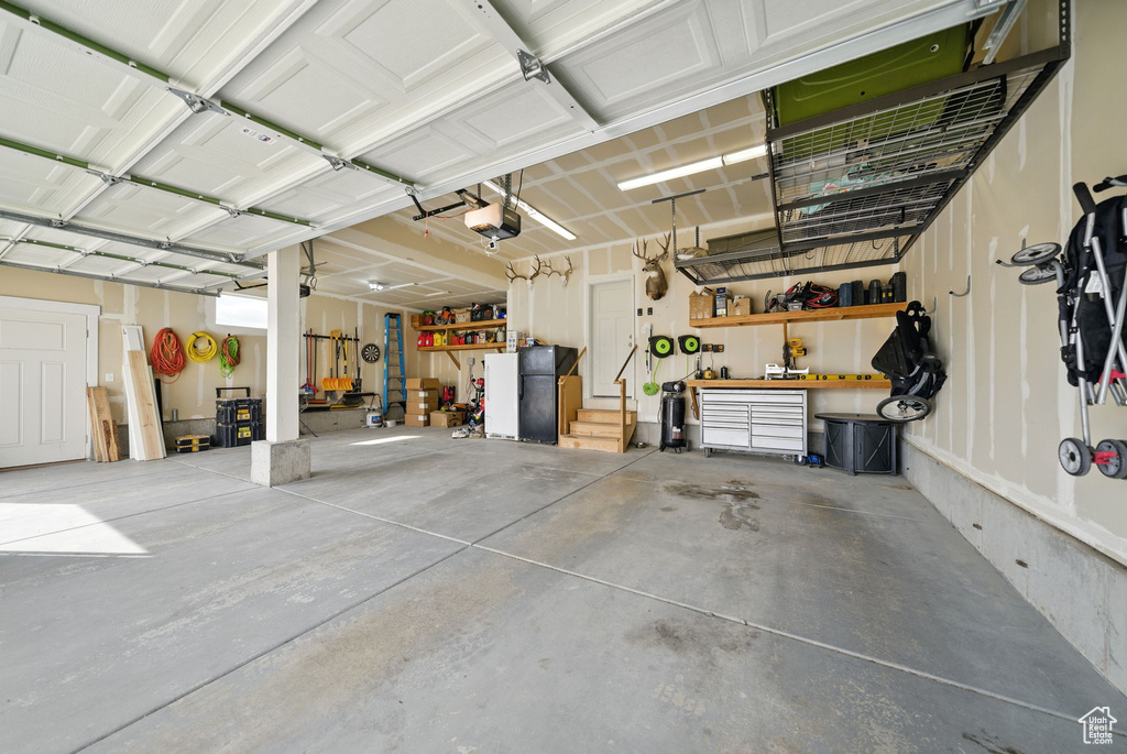 Garage featuring a workshop area and a garage door opener