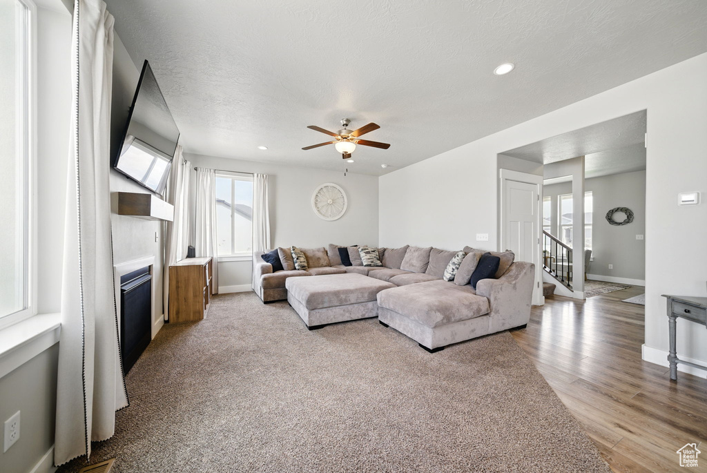 Living area featuring a large fireplace, healthy amount of natural light, baseboards, a ceiling fan, and recessed lighting
