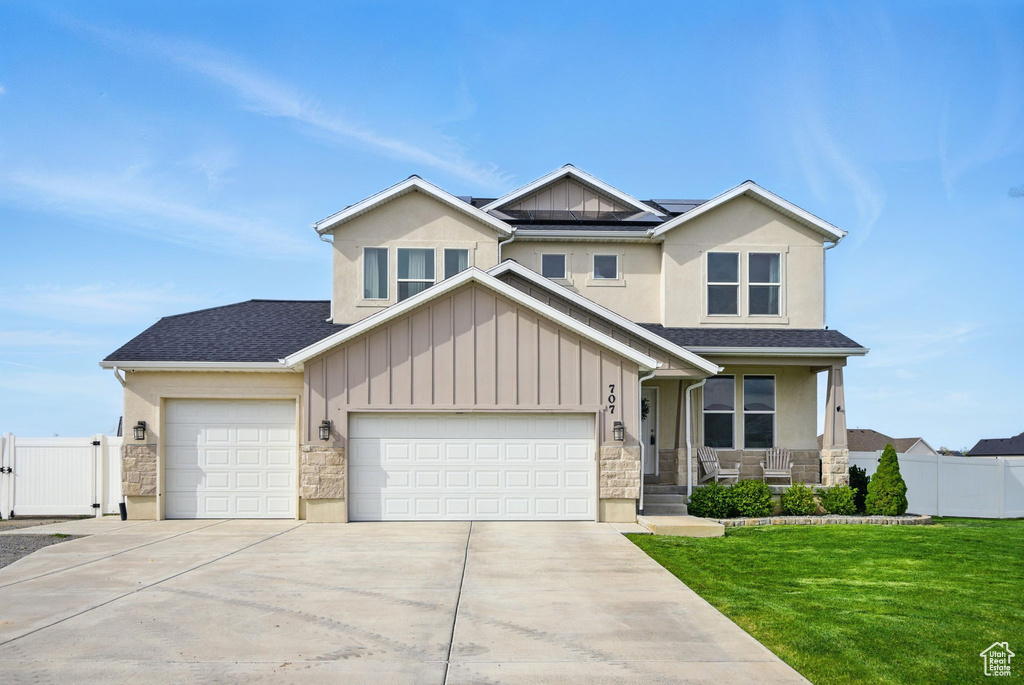 Craftsman-style house with a gate, stone siding, concrete driveway, and solar panels