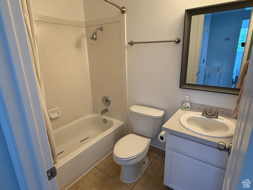 Bathroom featuring tile patterned floors, toilet, vanity, and tub / shower combination