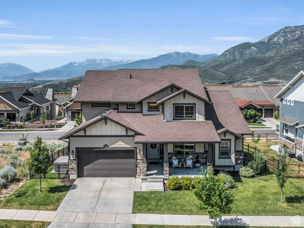View of front facade with fence, board and batten siding, a shingled roof, and concrete driveway