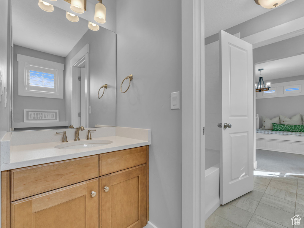 Full bath featuring vanity, ensuite bath, marble finish floor, and a notable chandelier