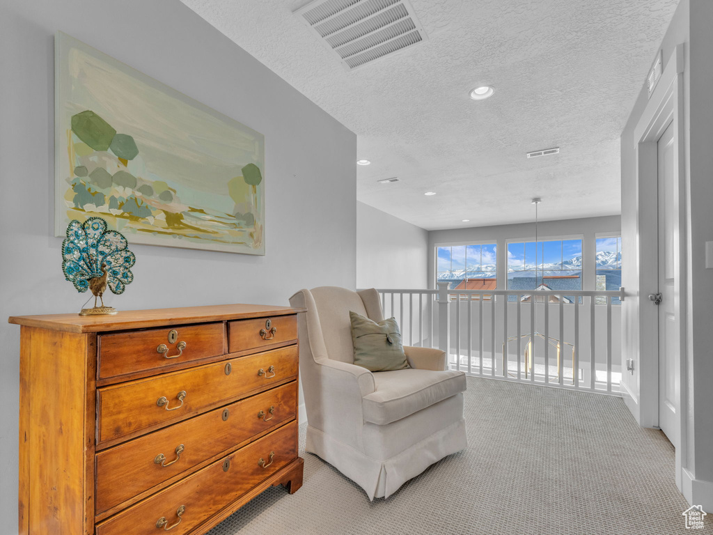 Living area featuring recessed lighting, a textured ceiling, visible vents, and light colored carpet
