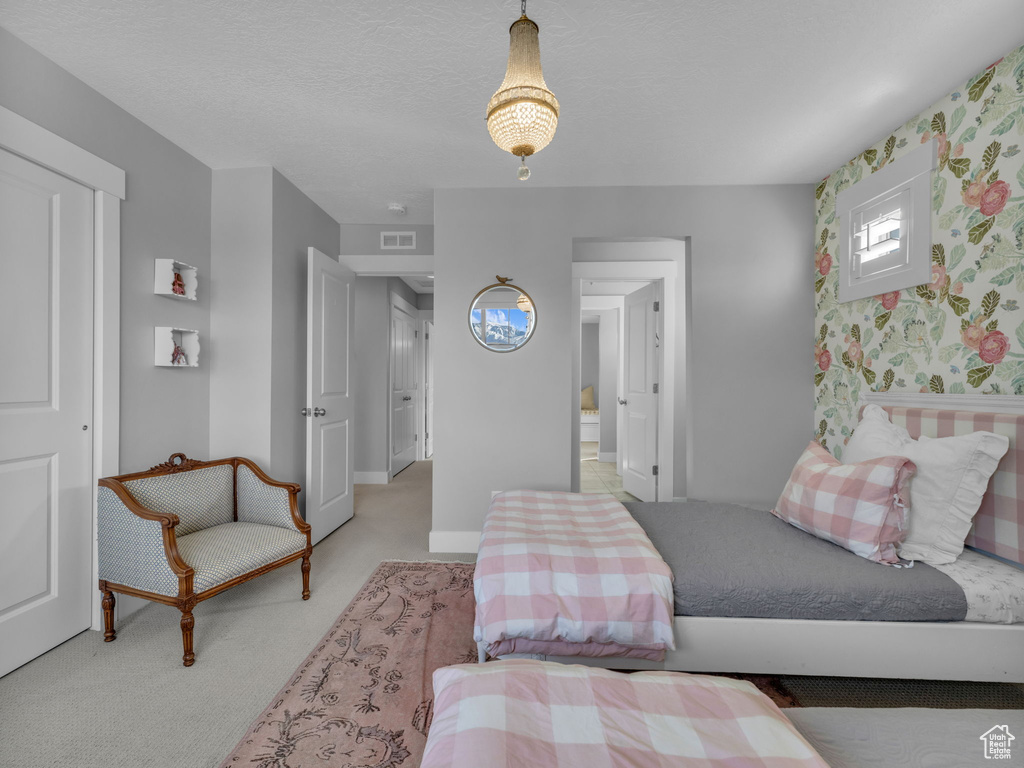 Bedroom with visible vents, wallpapered walls, carpet floors, and baseboards