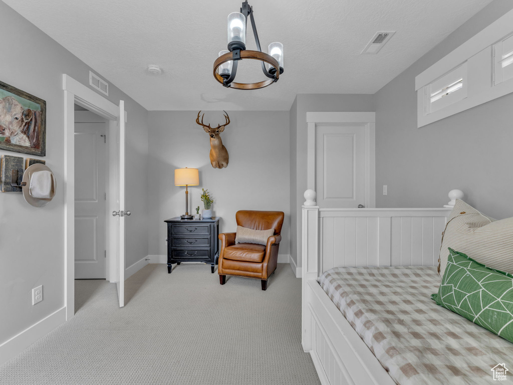 Bedroom with an inviting chandelier, visible vents, light carpet, and baseboards