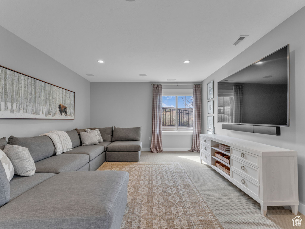 Living area with recessed lighting, visible vents, light colored carpet, and baseboards