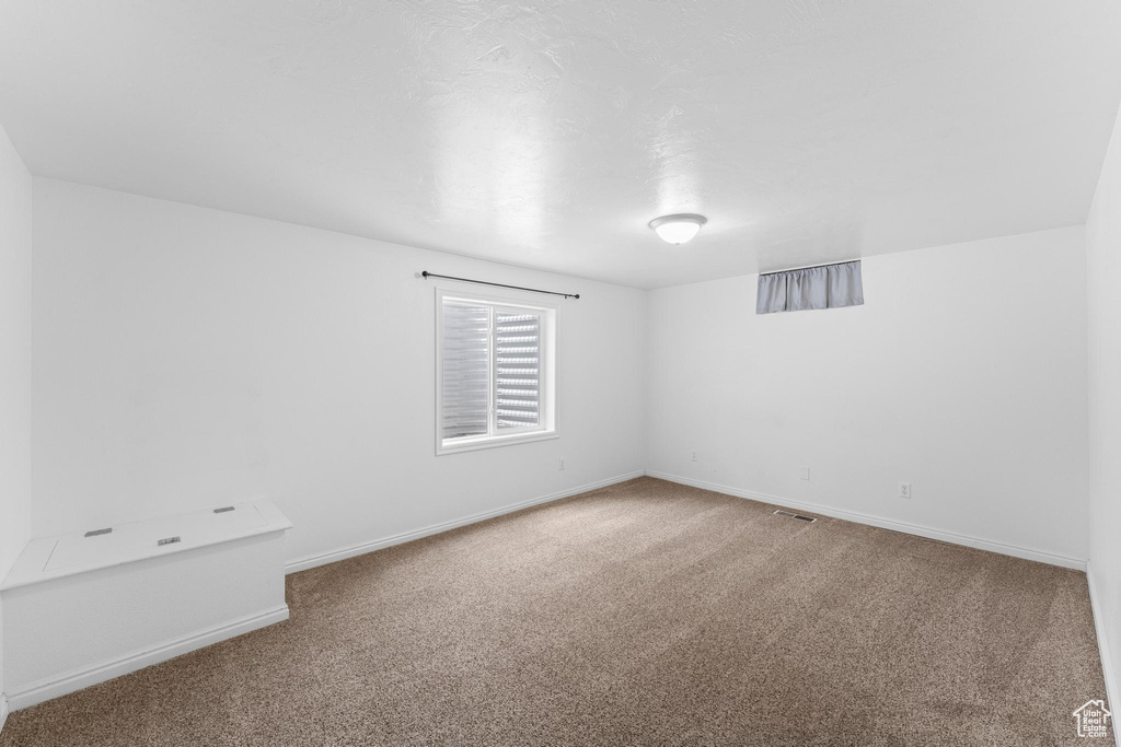 Empty room with carpet floors and baseboards