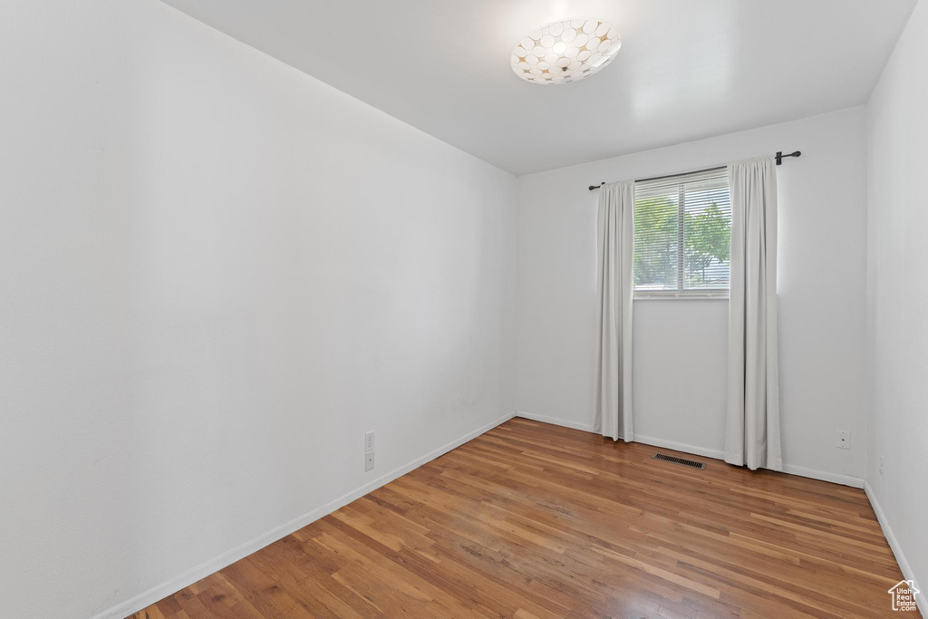 Unfurnished room featuring light wood finished floors and baseboards