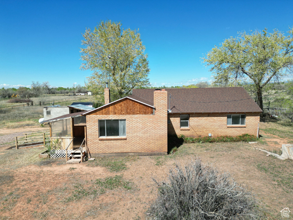 View of property exterior with a chimney and brick siding