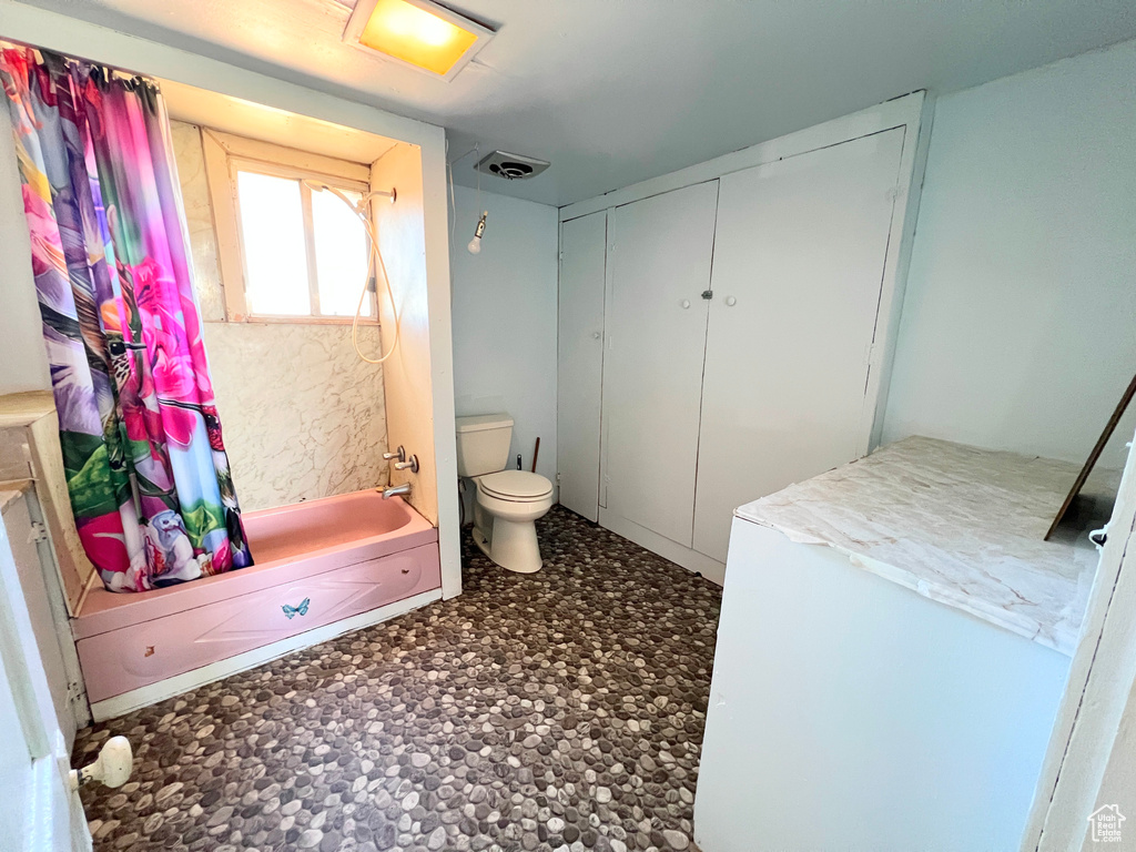 Bathroom featuring toilet and shower / bathtub combination
