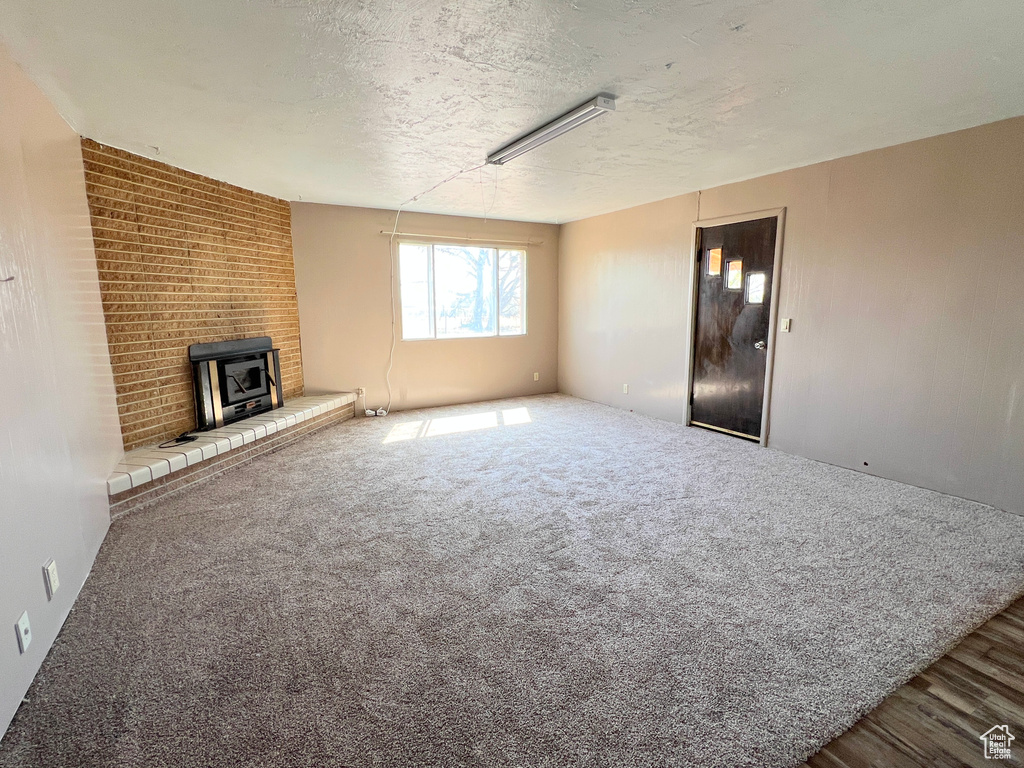Unfurnished living room with a textured ceiling and carpet