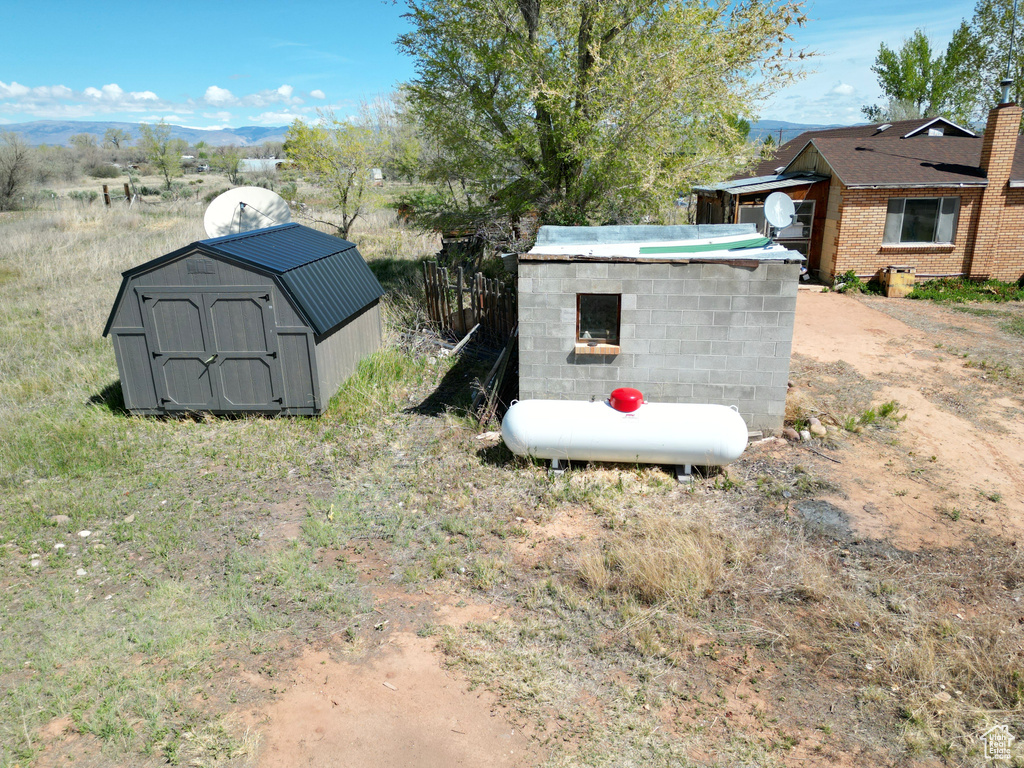 View of yard featuring a storage unit, an outdoor structure, and a mountain view