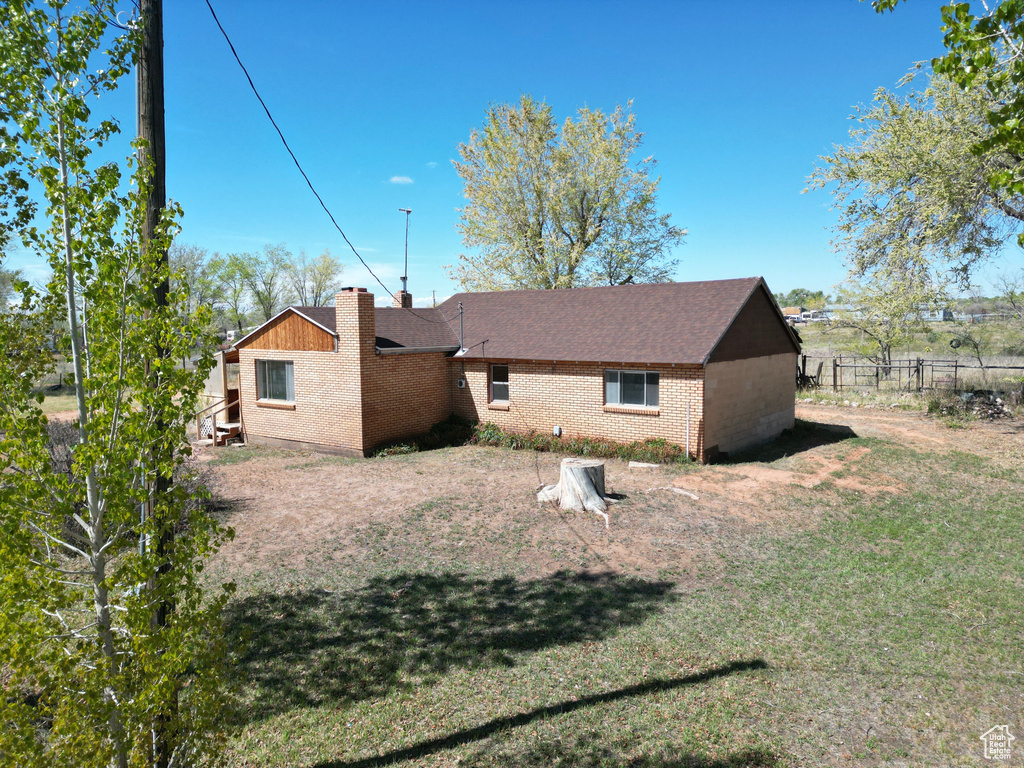 Back of house with brick siding and a shingled roof