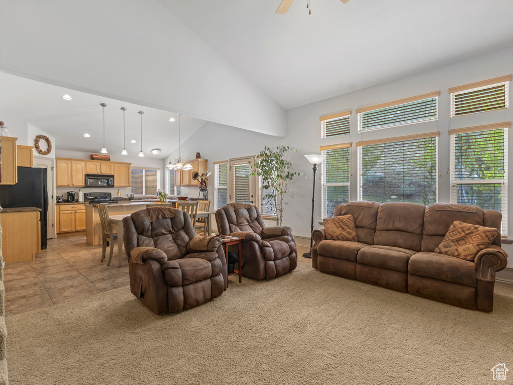 Living area with light carpet, a ceiling fan, a chandelier, recessed lighting, and high vaulted ceiling