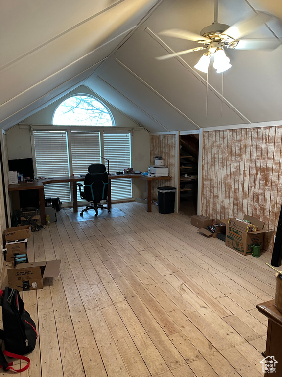 Home office with a ceiling fan, lofted ceiling, and hardwood / wood-style flooring
