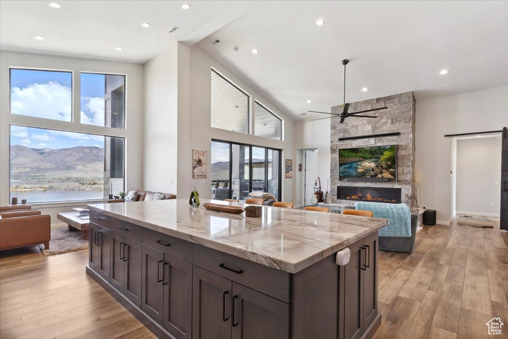Kitchen with open floor plan, a ceiling fan, light wood-style flooring, recessed lighting, and a center island