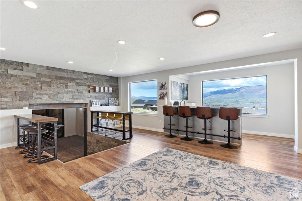 Indoor bar with wood finished floors, baseboards, and recessed lighting