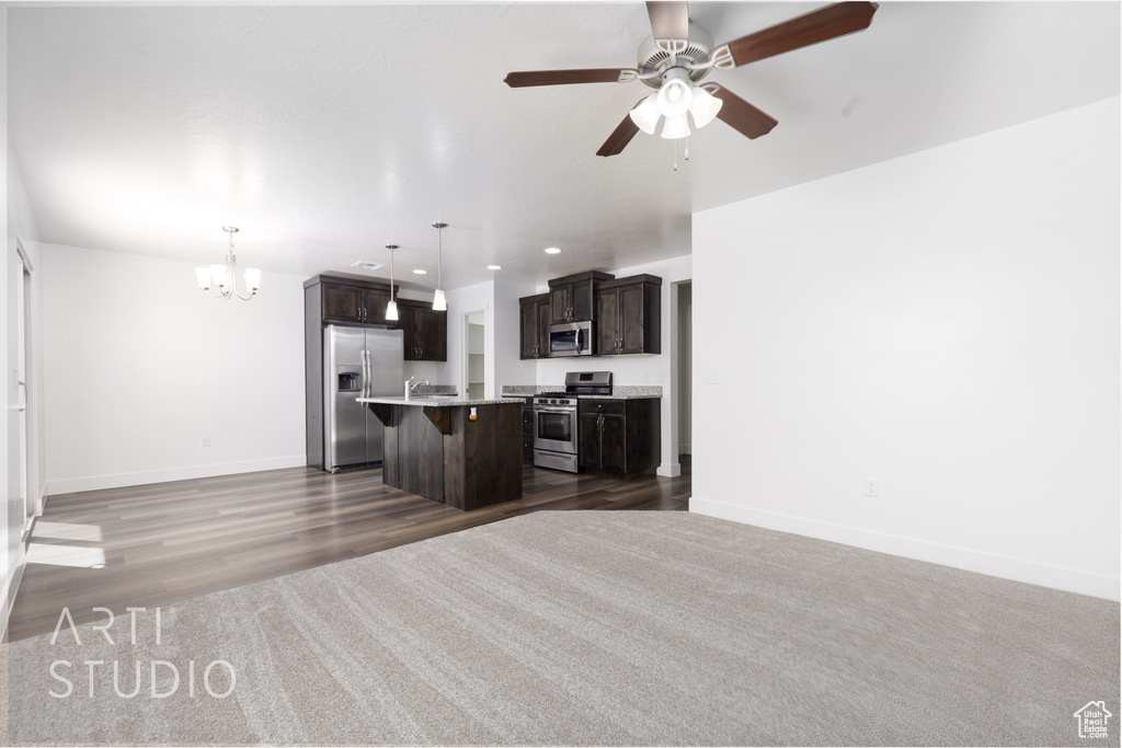 Unfurnished living room with a chandelier, a ceiling fan, baseboards, recessed lighting, and dark wood-type flooring