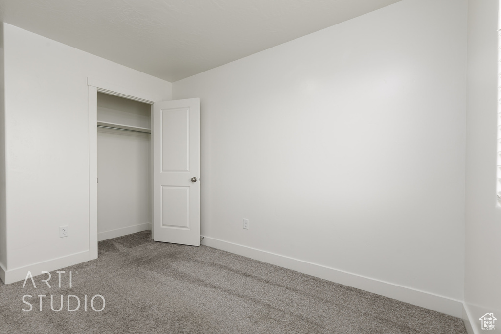Unfurnished bedroom with carpet, baseboards, and a closet
