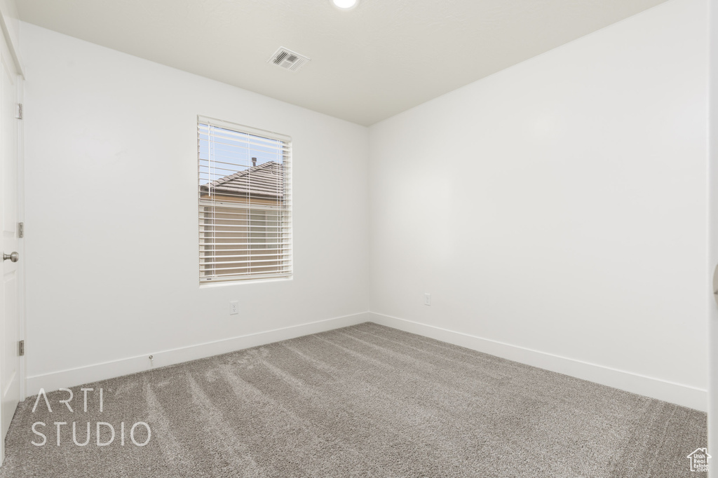 Empty room featuring baseboards and carpet