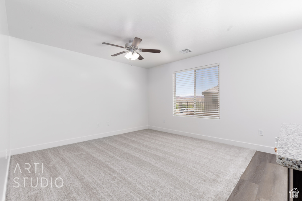 Spare room with ceiling fan and baseboards