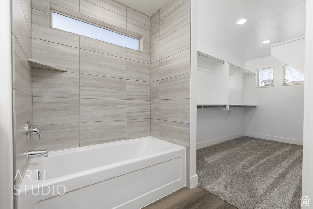 Bathroom with baseboards, a spacious closet, recessed lighting, and shower / bath combination
