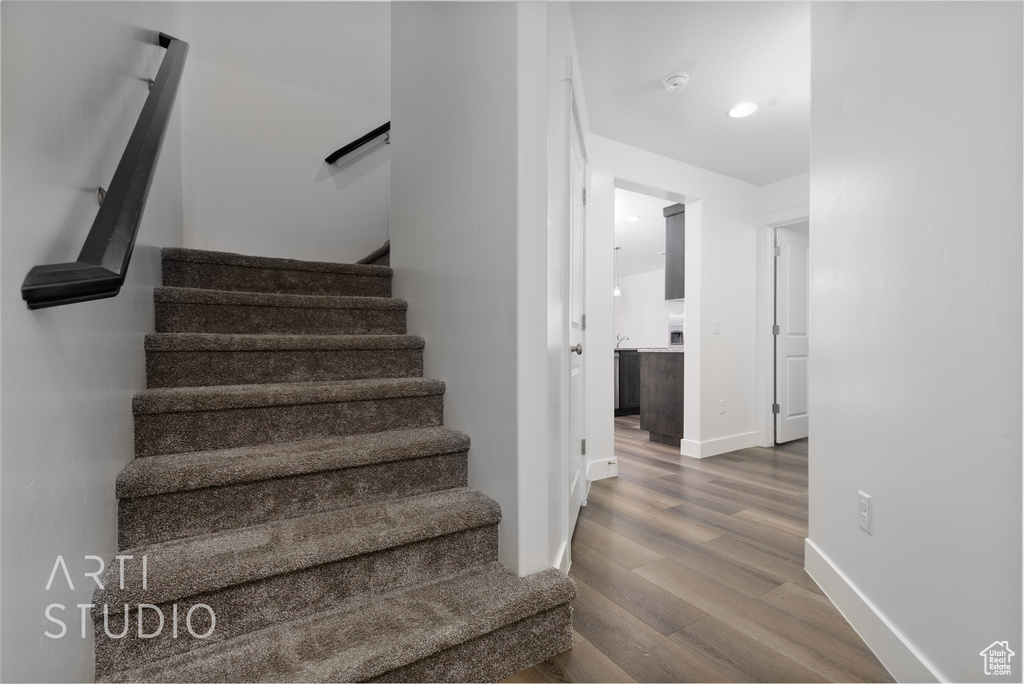 Staircase featuring wood finished floors and baseboards