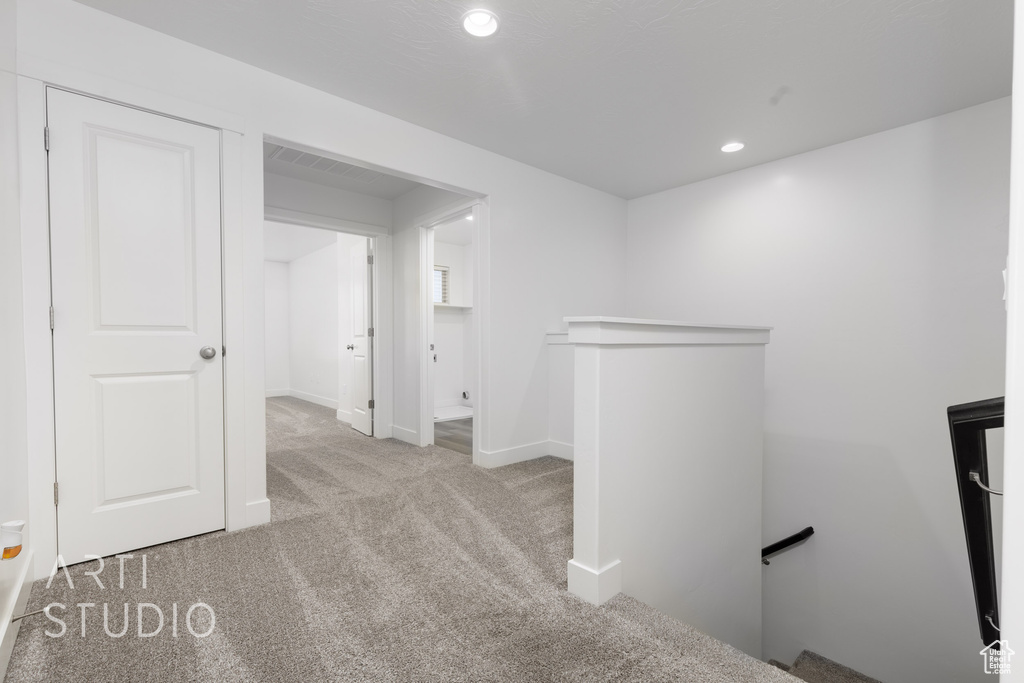 Hallway featuring an upstairs landing, carpet, recessed lighting, and baseboards