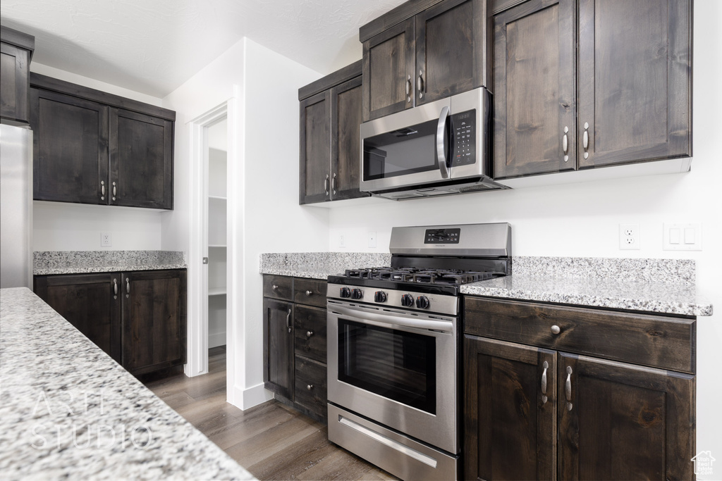 Kitchen featuring stainless steel appliances, dark wood-style floors, and dark brown cabinetry