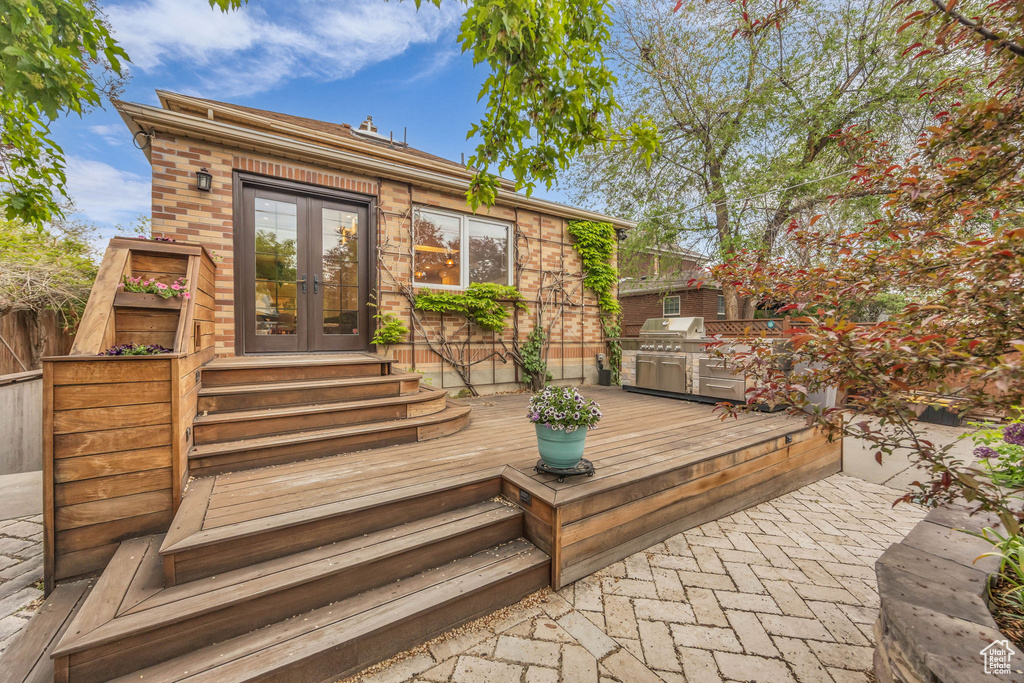 Wooden terrace featuring french doors, fence, and area for grilling