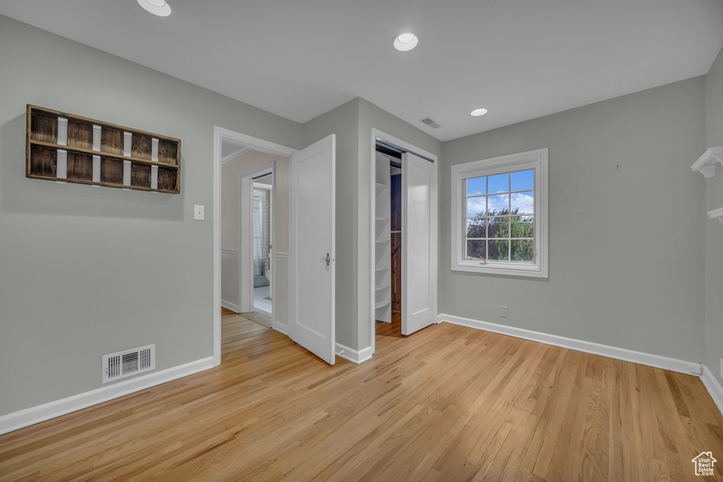 Unfurnished bedroom featuring baseboards, light wood-type flooring, a closet, and recessed lighting