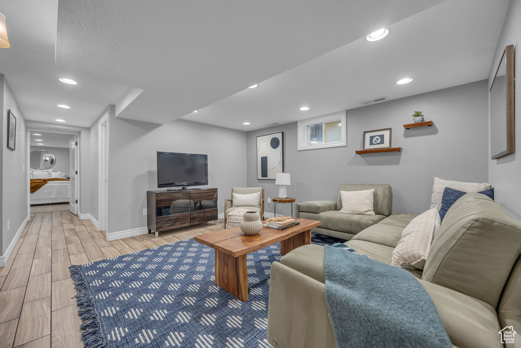 Living area with wood finish floors, baseboards, and recessed lighting