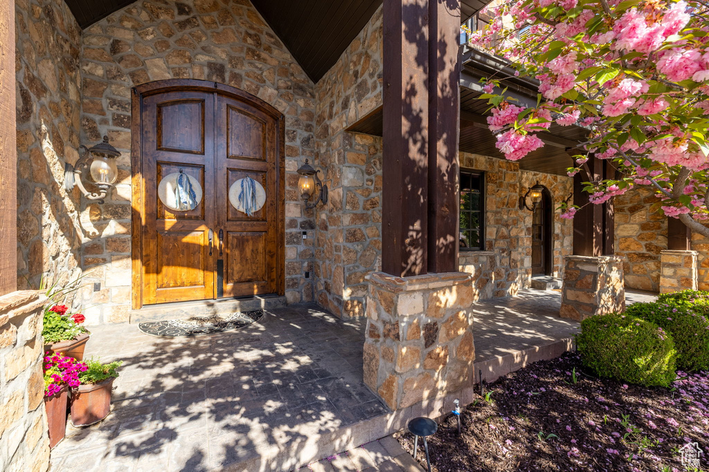 View of exterior entry featuring stone siding and covered porch