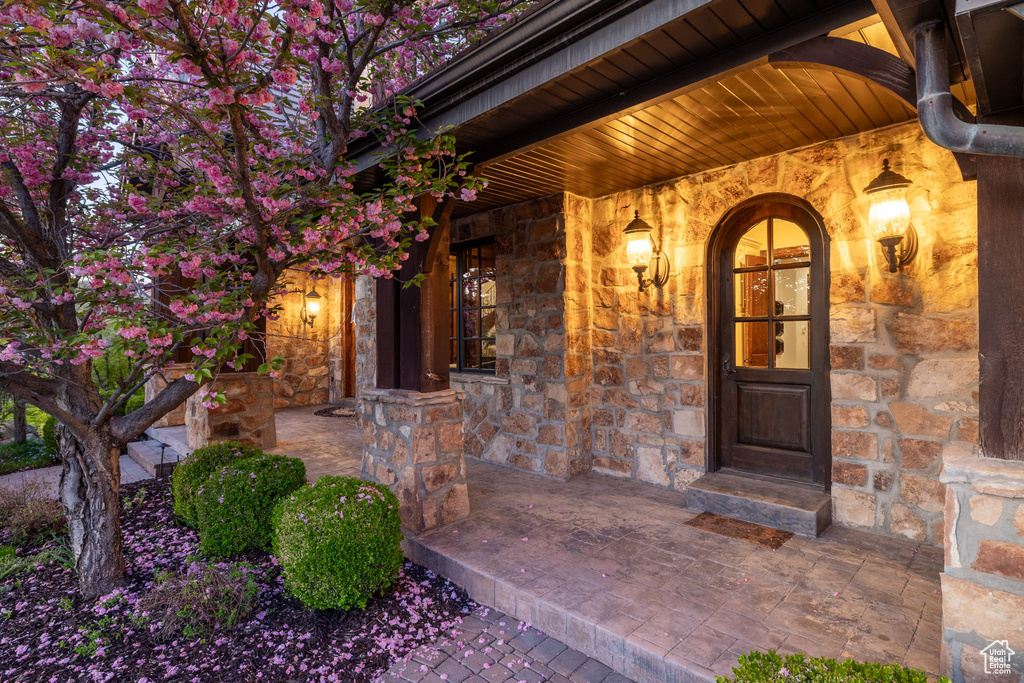 Property entrance featuring covered porch and stone siding