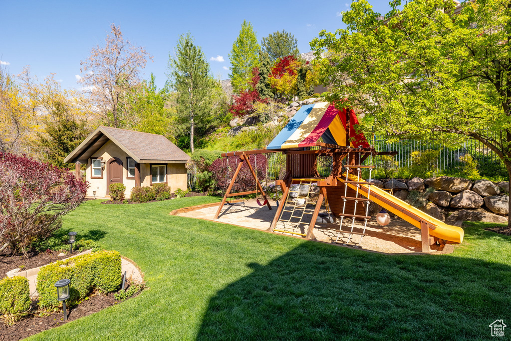 View of playground with a yard and fence