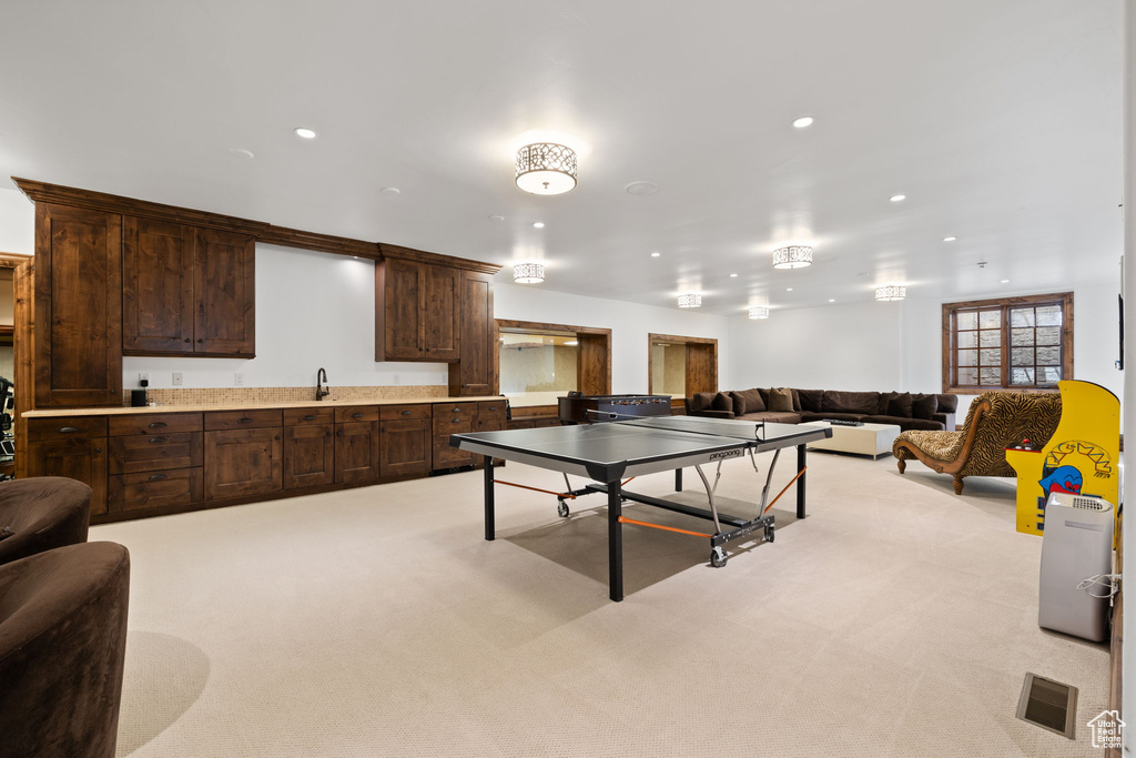 Recreation room featuring a sink, light colored carpet, visible vents, and recessed lighting