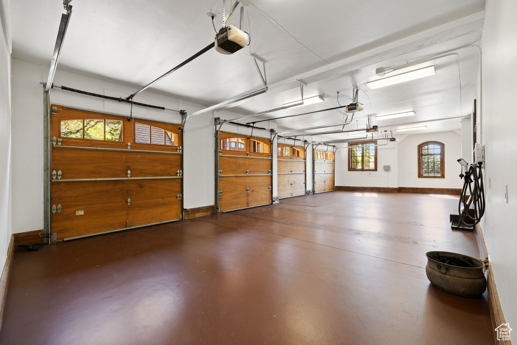 Garage with baseboards and a garage door opener