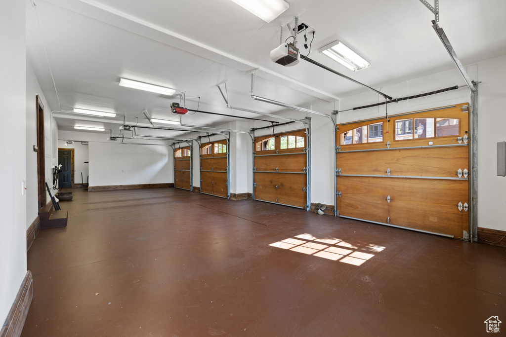 Garage with baseboards and a garage door opener