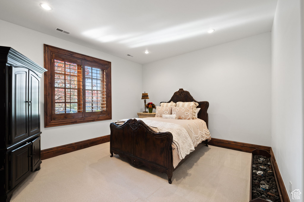 Bedroom with light colored carpet, visible vents, baseboards, and recessed lighting