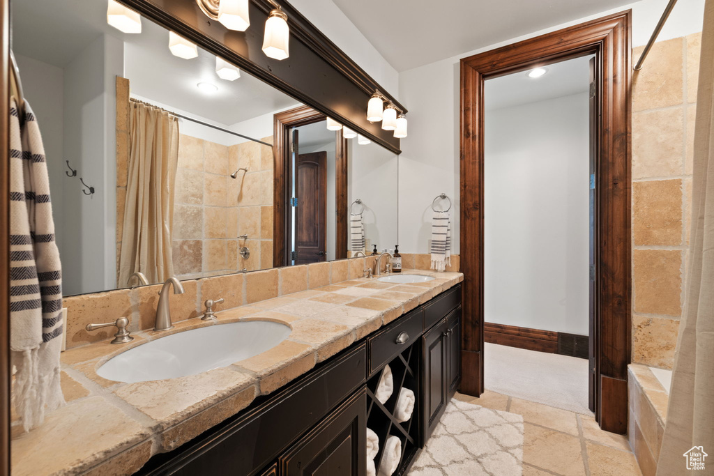 Bathroom featuring double vanity, a sink, and a shower with shower curtain